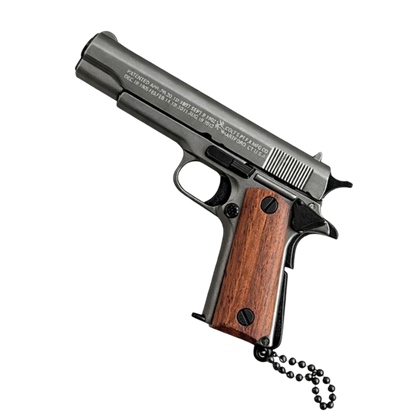 Miniature metal Colt 1911 pistol keychain with wooden grips and detachable ring
